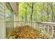 View of wooden deck with railing surrounded by trees and covered in fallen leaves at 5320 Liberty Hill W Rd, York, SC 29745