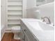 Bathroom with gray vanity, white sink, built-in shelves, and tile floor at 1209 Moretz Ave, Charlotte, NC 28206