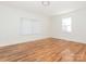 Bright bedroom featuring hardwood floors, white walls, and natural light from two windows at 1209 Moretz Ave, Charlotte, NC 28206