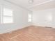 Bedroom featuring light-colored wood floors, two windows and a door at 1209 Moretz Ave, Charlotte, NC 28206