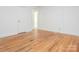 Bedroom features hardwood floors, white walls, and a door leading to another room at 1209 Moretz Ave, Charlotte, NC 28206