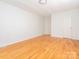 Spacious bedroom with hardwood floors, neutral walls, and modern lighting fixture at 1209 Moretz Ave, Charlotte, NC 28206