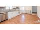 A kitchen with laminate floors, stainless steel dishwasher, and white cabinetry at 1209 Moretz Ave, Charlotte, NC 28206