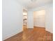 Open room with hardwood floors and a view into the kitchen and closet areas at 1209 Moretz Ave, Charlotte, NC 28206