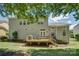 Large backyard featuring a wooden deck, mature trees, and a well-maintained lawn at 14027 Grand Traverse Dr, Charlotte, NC 28278