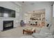 Bright living room features a fireplace, large windows, and an open layout connecting to the dining area and kitchen at 14027 Grand Traverse Dr, Charlotte, NC 28278
