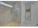 Elegant bathroom with a large walk-in shower and marble tile at 14535 Crosswater Ln, Charlotte, NC 28278