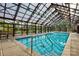 Indoor swimming pool with glass enclosure, creating a bright and airy atmosphere at 14535 Crosswater Ln, Charlotte, NC 28278