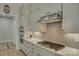 Clean kitchen showcasing white cabinets, gas cooktop and hexagon tile backsplash at 14535 Crosswater Ln, Charlotte, NC 28278