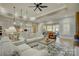 Open living room and kitchen with light beige sofas and a ceiling fan at 14535 Crosswater Ln, Charlotte, NC 28278