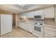 White kitchen with appliances and tile flooring at 7141 Stonington Ln, Charlotte, NC 28227