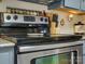 Close-up of the stainless steel stove and oven, complemented by tiled countertops and spice rack at 294 Carroll Cv, Clover, SC 29710