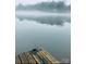 Misty lake scene with a glimpse of a wooden dock under a calm, gray sky creating a serene and moody atmosphere at 294 Carroll Cv, Clover, SC 29710