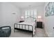 Calm bedroom with a black metal bed frame, white bedding, and plantation shutters, creating a serene atmosphere at 12023 Huntson Reserve Rd, Huntersville, NC 28078