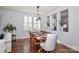 A formal dining room with an 8 seat table, hardwood floors, and a window with plantation shutters at 12023 Huntson Reserve Rd, Huntersville, NC 28078