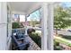 Comfortable front porch with two blue rocking chairs, surrounded by greenery, offering a relaxing view of the street at 12023 Huntson Reserve Rd, Huntersville, NC 28078