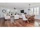 Open-concept living space with hardwood floors, plantation shutters, and a dining table off the living room area at 12023 Huntson Reserve Rd, Huntersville, NC 28078