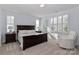 A bedroom with a bed, two bedside tables, and a white chair near a shuttered window at 12023 Huntson Reserve Rd, Huntersville, NC 28078