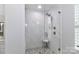 Modern glass enclosed walk-in shower featuring white marble tile, and a built-in seat at 12023 Huntson Reserve Rd, Huntersville, NC 28078