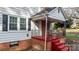 Front porch detail with red steps, brickwork, and black railings at 1235 10Th Ne St, Hickory, NC 28601