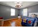 Bedroom with hardwood floors, two windows, and a wagon wheel chandelier at 2005 Robyn Ave, Shelby, NC 28152