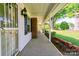 Covered porch view featuring brick accents, decorative lights, and a glimpse of the expansive front yard at 2005 Robyn Ave, Shelby, NC 28152
