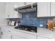 Modern kitchen featuring a gas cooktop, stylish blue tile backsplash, and white cabinets at 2146 Barrowcliffe Nw Dr, Concord, NC 28027