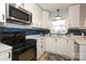 Modern kitchen with white cabinets and blue tile backsplash at 2701 Palm Ave, Charlotte, NC 28205