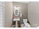 Stylish powder room with pedestal sink and oval mirror at 548 Summerfield Pl, Belmont, NC 28012