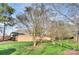 Landscaped backyard with trees and brick wall at 5635 Ballinard Ln, Charlotte, NC 28277