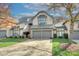 Tan two-story townhome with gray exterior accents and a two-car garage at 5635 Ballinard Ln, Charlotte, NC 28277