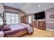 Main bedroom with hardwood floors, a large TV, and ample closet space at 5635 Ballinard Ln, Charlotte, NC 28277