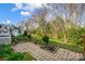 Landscaped backyard featuring stone patio, flower beds, and lush greenery at 7943 Oratorio Pl, Charlotte, NC 28270