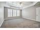 A Primary bedroom with carpet floors, a tray ceiling, a ceiling fan, and plantation shutters at 7943 Oratorio Pl, Charlotte, NC 28270