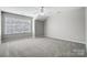 Spacious bedroom featuring neutral walls, carpet, ceiling fan, and a large window at 7943 Oratorio Pl, Charlotte, NC 28270