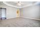 A Primary bedroom with carpet floors, a tray ceiling, and two entryways at 7943 Oratorio Pl, Charlotte, NC 28270