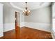 Dining room showcasing hardwood floors, wainscoting, and a modern chandelier at 7943 Oratorio Pl, Charlotte, NC 28270