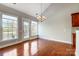 A sunlit dining area with hardwood floors, a chandelier, and views of the backyard at 7943 Oratorio Pl, Charlotte, NC 28270