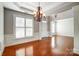 Living room boasting hardwood floors, natural light, detailed trim work, and a chandelier at 7943 Oratorio Pl, Charlotte, NC 28270