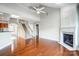 Living room featuring hardwood floors, a fireplace, and staircase at 7943 Oratorio Pl, Charlotte, NC 28270