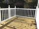 Freshly-stained back deck with white decorative railings is perfect for entertaining or enjoying the view of a lush backyard at 8350 Nc Hwy 90 E Hwy, Stony Point, NC 28678