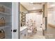 Bright bathroom with a tub and floral shower curtain, complimented by white vanity and decorative touches at 9130 Dulwich Dr # Ken0079, Charlotte, NC 28215