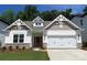 Charming home showcasing a manicured lawn, brick accents, and a well-lit two-car garage at 9130 Dulwich Dr # Ken0079, Charlotte, NC 28215