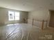 Spacious loft area with natural light, featuring white railing and neutral walls at 9130 Dulwich Dr # Ken0079, Charlotte, NC 28215