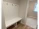 Mudroom with a white bench and coat rack, complemented by light-colored wood flooring at 9130 Dulwich Dr # Ken0079, Charlotte, NC 28215