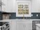 Bright kitchen with white cabinets, a farmhouse sink, and a view to the backyard at 201 Seneca Pl, Charlotte, NC 28210