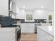 Newly renovated kitchen featuring white cabinets, stainless steel appliances, and hexagon tile backsplash at 201 Seneca Pl, Charlotte, NC 28210