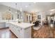 Open kitchen with large island, white cabinets and hardwood floors at 3014 Highbury Pl, Weddington, NC 28104