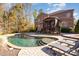 Freeform pool with stone patio, lounge chairs, and house view at 3014 Highbury Pl, Weddington, NC 28104