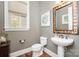 Elegant powder room with a pedestal sink and decorative mirror at 3014 Highbury Pl, Weddington, NC 28104